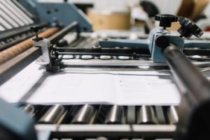 Large white sheets being printed on a machine